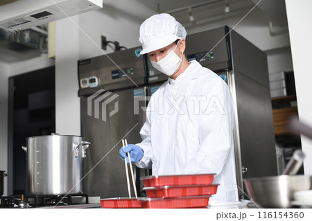 弁当箱に料理を詰める男性の調理スタッフ 116154360