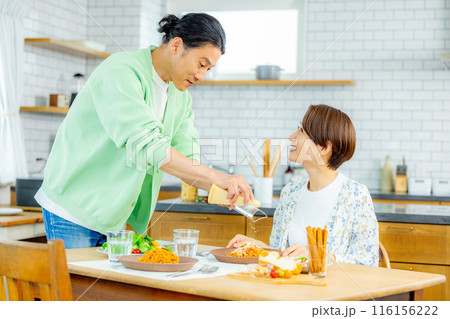 ランチを食べる夫婦 チーズをかける ランチを食べる夫婦 チーズをかける 116156222