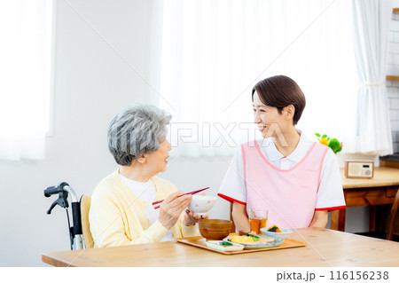 食事をする介護士と老人 116156238