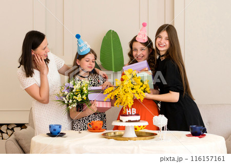 Mother and daughters celebrating birthday at home. 116157161