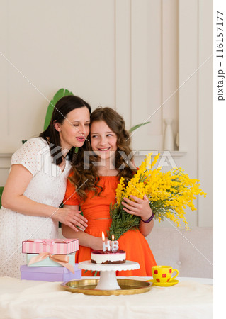 Girl in orange dress celebrating birthday with mom 116157177