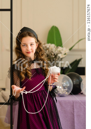 Girl holding pearls and smiling 116157674