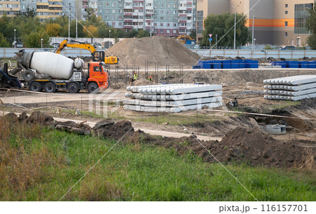 Concreting work at the construction site. Construction workers pour liquid concrete from cement concrete hopper to formwork installation. Concreting work at the construction site. Construction workers pour liquid concrete from cement concrete hopper to formwork installation. 116157701