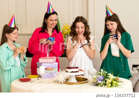 Birthday girl surrounded by family and friends Birthday girl surrounded by family and friends 116157712
