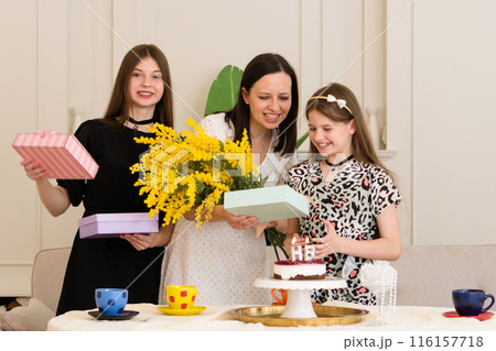 Woman and two girls celebrating birthday 116157718