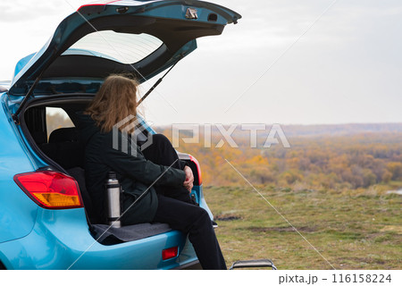 A young girl stands on a high bank and looks at the beautiful nature A young girl stands on a high bank and looks at the beautiful nature 116158224