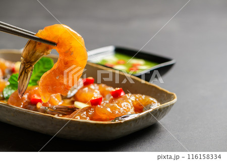 Pickled shrimp with chopstick Soy Sauce, chilli and garlic on stone background, 116158334
