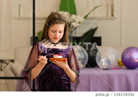 Girl enjoying a piece of cake at birthday party. 116158392