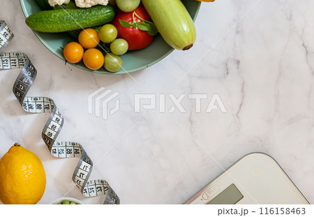 Diet and Healthy Life Weight Loss Concept. Organic green apple and scales measure faucet with vegan plant and sports equipment for women's body weight loss diets are suitable. Top view and copy space. 116158463