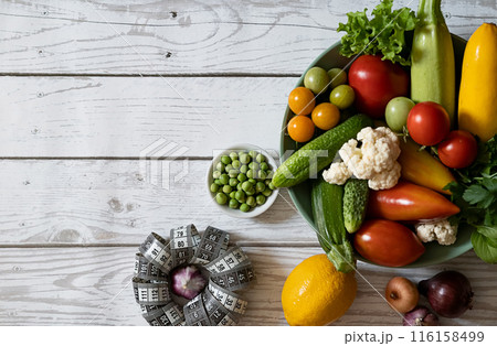 Diet plan, menu or program, roulette, water, dumbbells and diet food from fresh fruits on a white background, the concept of weight loss and detoxification, top view Diet plan, menu or program, roulette, water, dumbbells and diet food from fresh fruits on a white background, the concept of weight loss and detoxification, top view 116158499