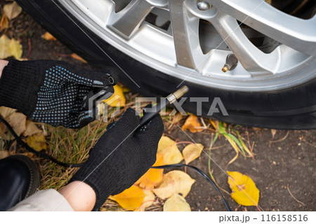 man driver hand inflating tires of vehicle, removing tire valve nitrogen cap for checking air pressure and filling air on car wheel at gas station. self service, maintenance and safety man driver hand inflating tires of vehicle, removing tire valve nitrogen cap for checking air pressure and filling air on car wheel at gas station. self service, maintenance and safety 116158516