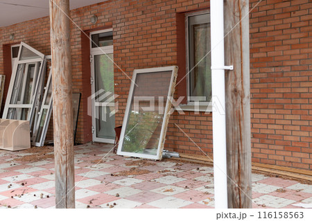View of the unfinished wall of the house. New windows in the house. 116158563