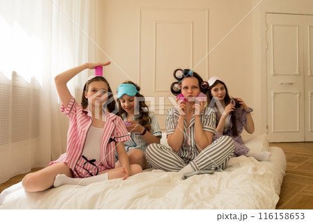 Girls and mom laugh and enjoy a pajama party. 116158653