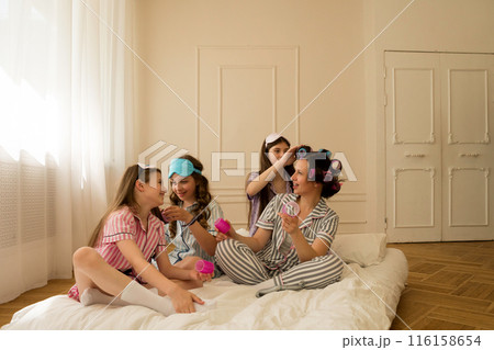 Girls and mom with curlers having fun at home. 116158654