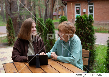A teenage girl and an older woman spend time together. 116158769