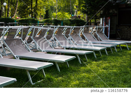 Row of sunloungers near the swimming pool, lounge chairs 116158776