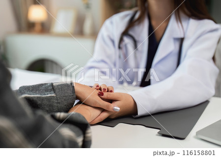 Female Doctor Comforting Patient During Consultation in Modern Medical Office 116158801