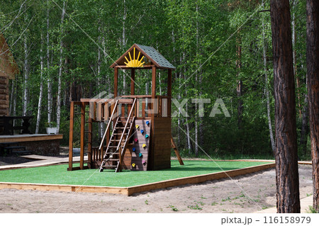 Children Playground with Modern Slide, Rope Net Bridge, Climbing Swings, Climbers. Empty Wooden Playground made of Eco Materials - Wooden Tree trunk Logs Robinia. 116158979