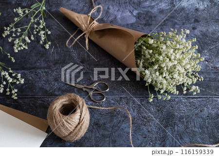 Medium height woman working with dried flowers assemble composition, decor and floristry concept 116159339