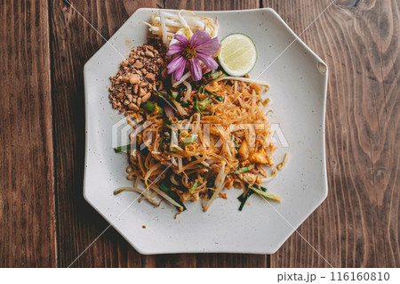 Above angle view of luxury style of Pad Thai dish decorated with purple flower. 116160810