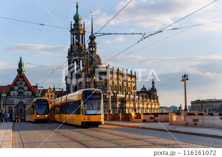 Scenic Dresden cityscape yellow tram crossing Augustus bridge Elbe river Theaterplatz and Hofkirche Cathedral sunset background. Travel city tour trip Germany Saxony capital city sightseeing landmark 116161072