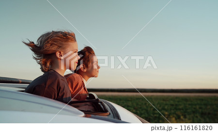 Funny Happy Little Boys Stands In Open Car Sunroof During Trip, Summer.Childhood Funny Happy Little Boys Stands In Open Car Sunroof During Trip, Summer.Childhood 116161820