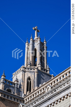 tower and spire ancient Catholic Church with stone cross in Gothic style. Cathedral of Sacred Heart of Jesus in Tashkent 116162280