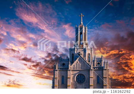 tower and spire of the gothic ancient Catholic Cathedral on background of dramatic sky at sunset. Polish Church Cathedral of Sacred Heart of Jesus in Tashkent in Uzbekistan, Asia tower and spire of the gothic ancient Catholic Cathedral on background of dramatic sky at sunset. Polish Church Cathedral of Sacred Heart of Jesus in Tashkent in Uzbekistan, Asia 116162292