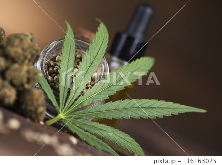 Hemp oil and cannabis leaves on light background Hemp oil and cannabis leaves on light background 116163025