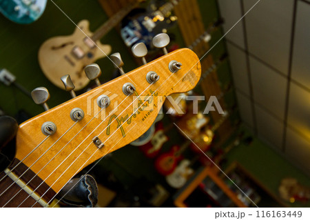 Close-up of Electric Guitar Headstock in Music Store Atmosphere 116163449