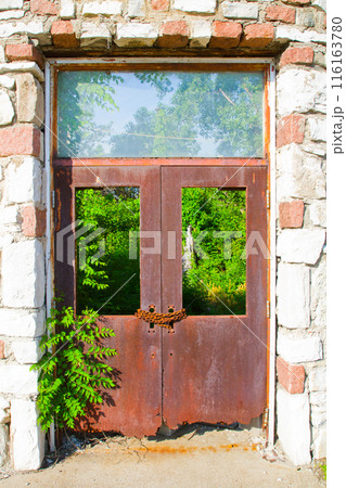 Rusty Double Doors in Stone Frame with Nature's Overgrowth, Rural Missouri 116163780