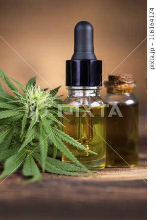 Cbd hemp oil in bottle and marijuana leaves 116164124