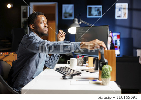 System admin generating IT scripts for data centers and developing program in machine language. On HTML terminal window, engineering specialist typing code in binary, ensures server security. 116165693