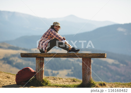Male Hiker Resting on Bench in Carpathian Mountains, Ukraine Male Hiker Resting on Bench in Carpathian Mountains, Ukraine 116168482