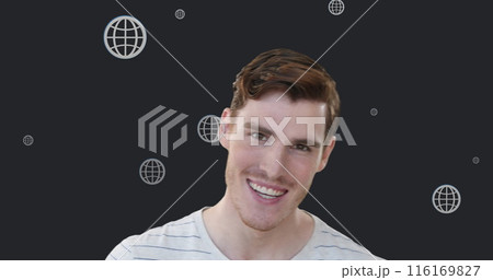 Image of multiple web globe icons floating over caucasian man smiling against grey background 116169827