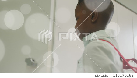 Image of white light spots over african american schoolboy using his locker 116170168