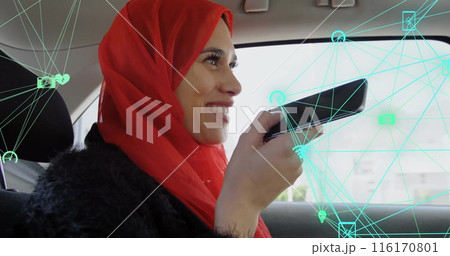 Image of connected icons globes over caucasian woman wearing hijab using voice assistant in car 116170801
