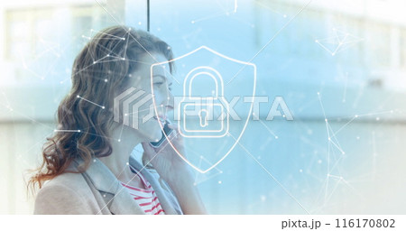 Image of padlock in shield, connected icons over caucasian woman talking on smartphone 116170802