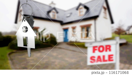 Image of silver house key fob and key, hanging in front of blurred house with for sale sign Image of silver house key fob and key, hanging in front of blurred house with for sale sign 116171068