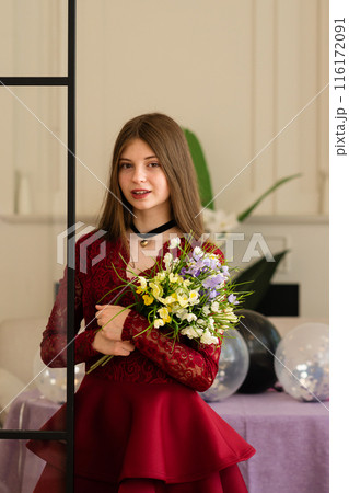 Teen girl in red lace dress holding bouquet of flowers 116172091