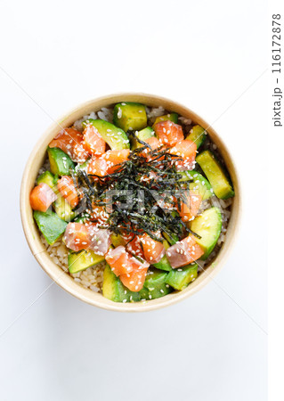 poke bowl with diced raw salmon fish and avocado on sushi rice in paper container. poke bowl with diced raw salmon fish and avocado on sushi rice in paper container. 116172878