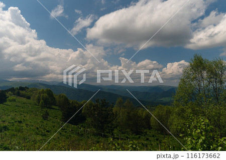 Mountainous landscape with clouds overhead. Mountainous landscape with clouds overhead. 116173662