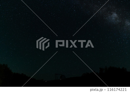 Starry night sky with Milky Way above an observatory silhouette. 116174221