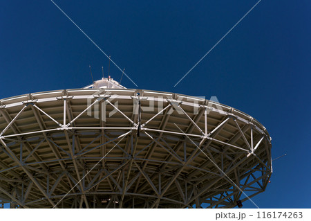 Large satellite dish antenna against clear blue sky. 116174263