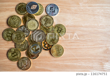 Top view of various kinds of cryptocurrency token coins on wooden table. Cryptocurrency is a digital or virtual currency that is secured by cryptography. 116174751
