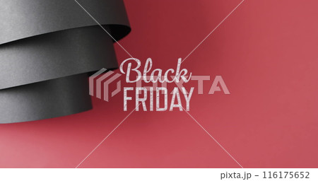 Image of black friday text over rolled up black paper on red background 116175652
