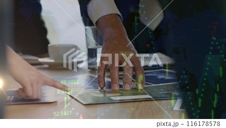 Two people wearing business attire are examining documents on table 116178578