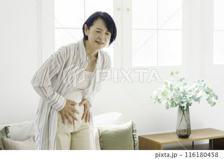 お腹をおさえるミドルエイジの女性 腹痛 お腹をおさえるミドルエイジの女性 腹痛 116180458