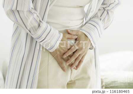 お腹をおさえるミドルエイジの女性の手のアップ 116180465