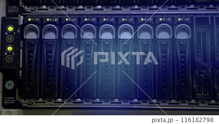 Rows of hard drives glowing in blue inside server rack 116182798